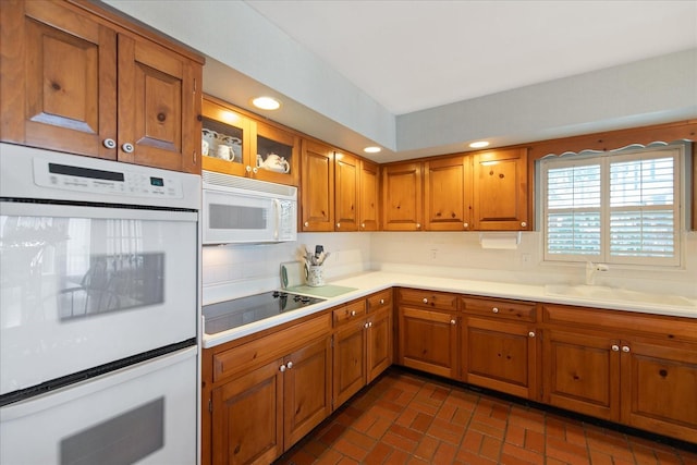 kitchen featuring white appliances, sink, and tasteful backsplash