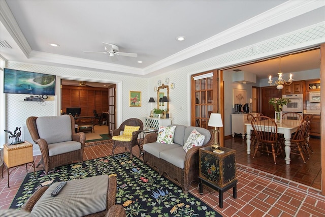 living room with crown molding and ceiling fan with notable chandelier