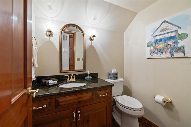 half bath featuring toilet, lofted ceiling, and vanity