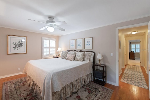 bedroom featuring multiple windows, ceiling fan, crown molding, and light hardwood / wood-style flooring