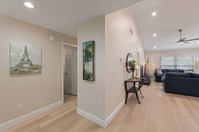 hallway featuring light wood finished floors, recessed lighting, and baseboards