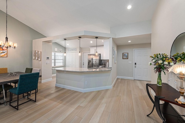 kitchen with stainless steel fridge, a notable chandelier, light wood-style flooring, and white cabinets