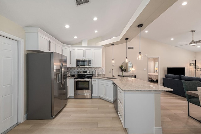 kitchen featuring visible vents, open floor plan, appliances with stainless steel finishes, a peninsula, and a sink