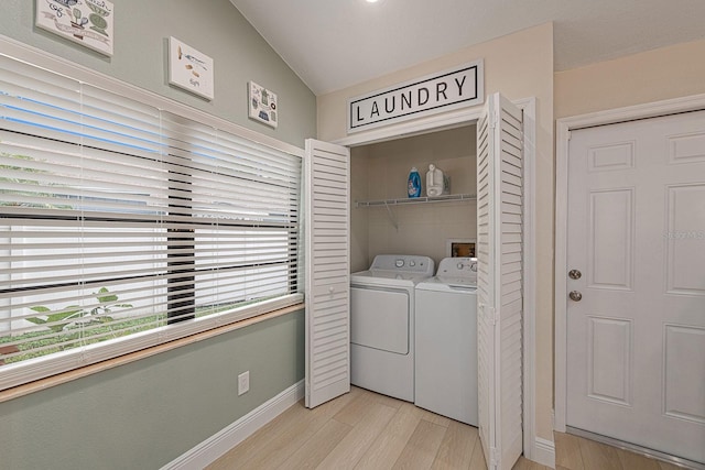 washroom featuring washer and dryer, baseboards, light wood-style flooring, and laundry area