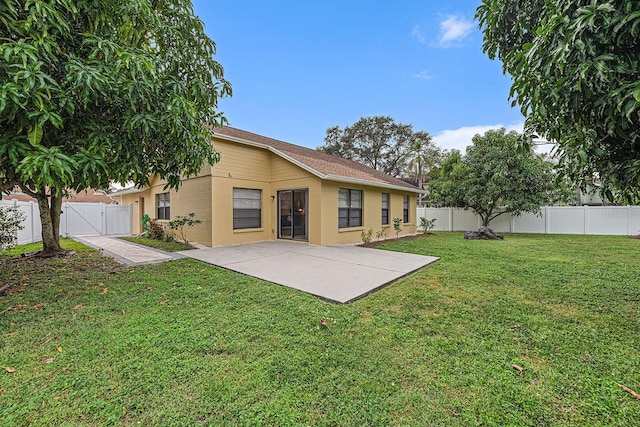 back of property featuring a gate, a patio area, a lawn, and a fenced backyard