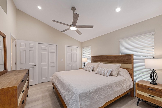 bedroom with multiple closets, recessed lighting, light wood-style floors, lofted ceiling, and ceiling fan