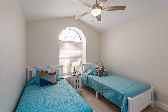 bedroom featuring lofted ceiling, light wood-style flooring, and a ceiling fan