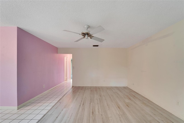 unfurnished room with a textured ceiling, ceiling fan, and light wood-type flooring