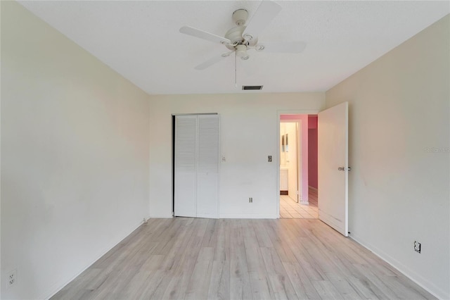 unfurnished bedroom featuring ceiling fan, a closet, and light hardwood / wood-style floors