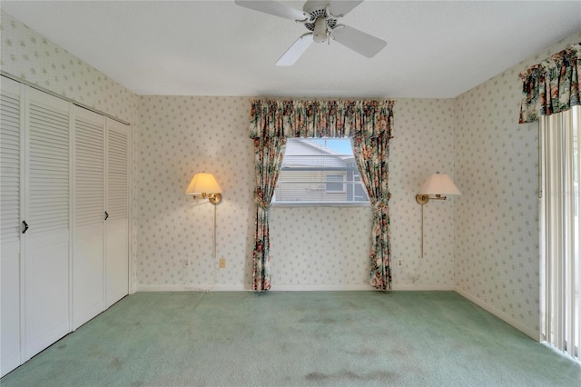 unfurnished bedroom with carpet flooring, ceiling fan, and a closet