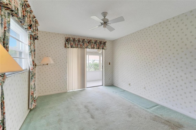 carpeted spare room with ceiling fan and a textured ceiling