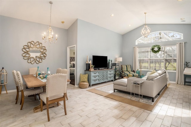 living room featuring plenty of natural light, high vaulted ceiling, a chandelier, and light hardwood / wood-style floors