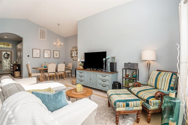 living area featuring arched walkways, visible vents, lofted ceiling, and an inviting chandelier