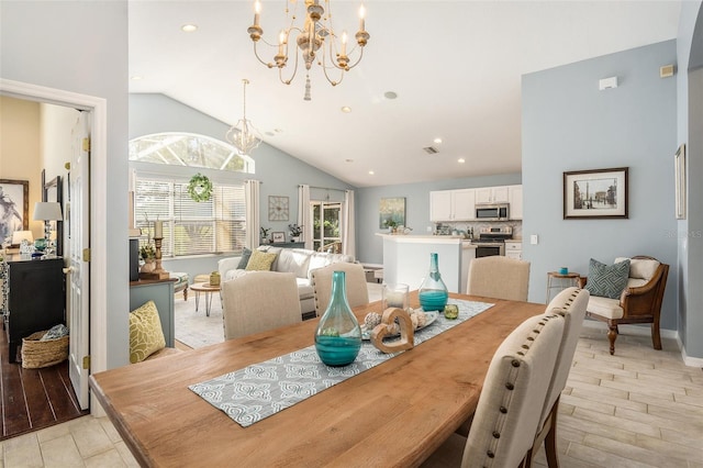 dining area featuring high vaulted ceiling, light hardwood / wood-style flooring, and a notable chandelier