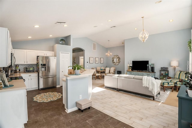 interior space featuring white cabinetry, a chandelier, stainless steel appliances, a kitchen island, and hanging light fixtures