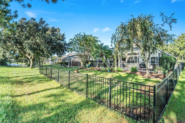 view of yard with glass enclosure and fence