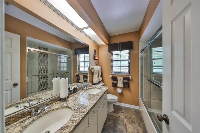 full bathroom with vanity, toilet, and combined bath / shower with glass door