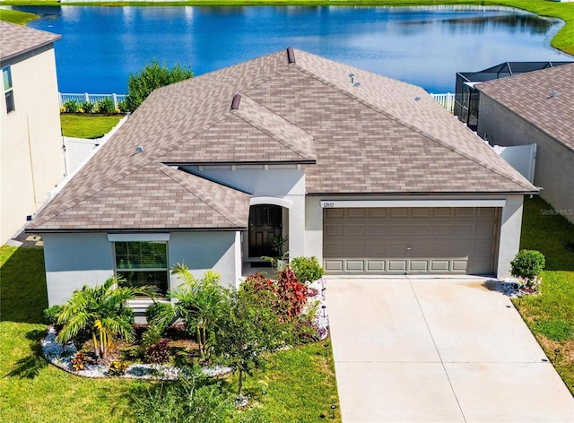 view of front facade featuring a garage, a water view, roof with shingles, and stucco siding