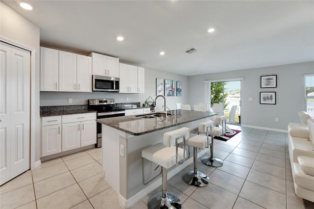 kitchen with white cabinets, plenty of natural light, stainless steel appliances, and sink