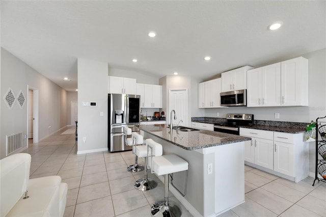 kitchen featuring white cabinets, an island with sink, stainless steel appliances, and sink