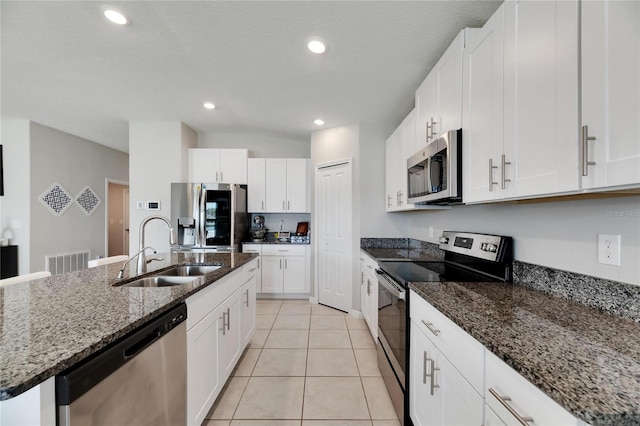 kitchen featuring white cabinets, appliances with stainless steel finishes, and a kitchen island with sink