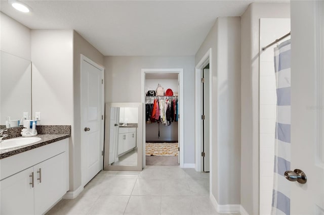 bathroom featuring vanity, a shower, and tile patterned flooring