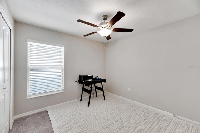 interior space with a textured ceiling, plenty of natural light, ceiling fan, and carpet