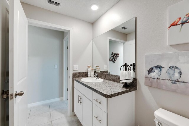 bathroom featuring vanity, toilet, and tile patterned floors