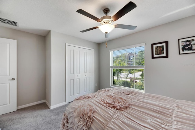 bedroom with carpet, a textured ceiling, ceiling fan, and a closet