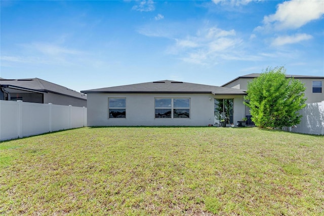 rear view of property with a lawn