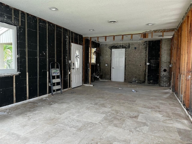 unfurnished room with a textured ceiling