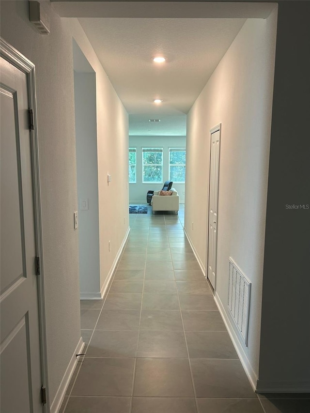 hallway with tile patterned floors