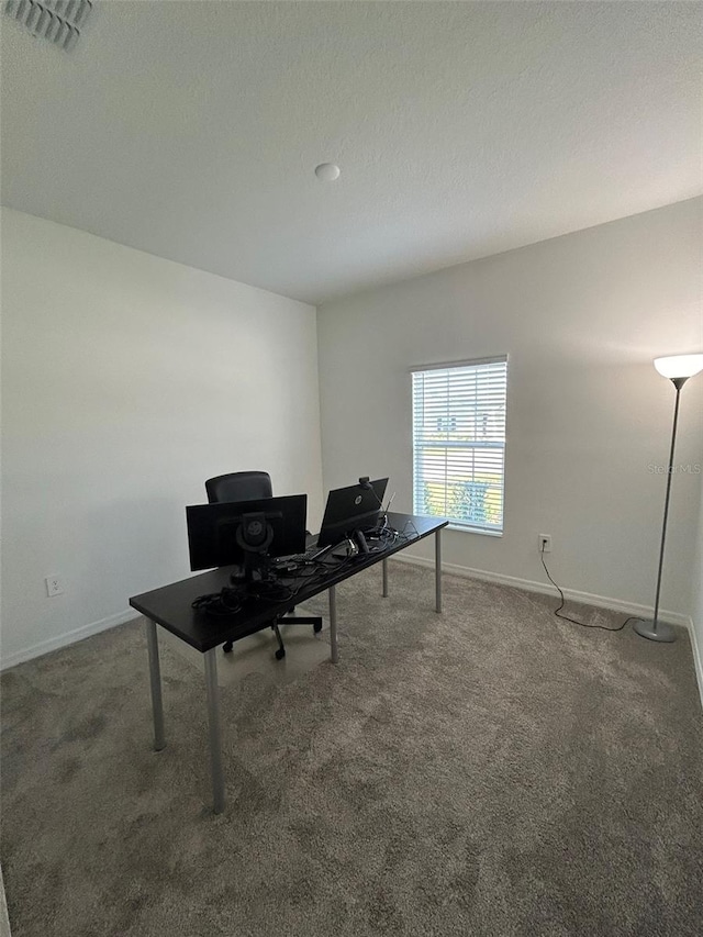 office space featuring a textured ceiling and dark carpet