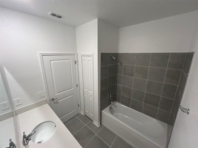 bathroom with tiled shower / bath, tile patterned floors, and vanity