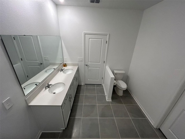 bathroom featuring toilet, vanity, and tile patterned flooring