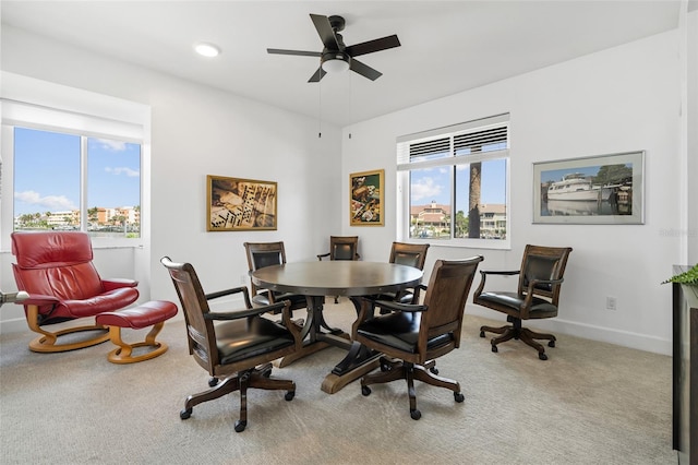 carpeted dining space with ceiling fan