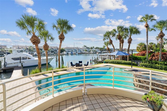 view of swimming pool featuring a water view and a dock