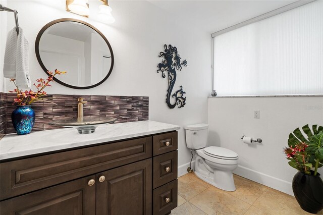 bathroom with tile patterned flooring, toilet, tasteful backsplash, and vanity