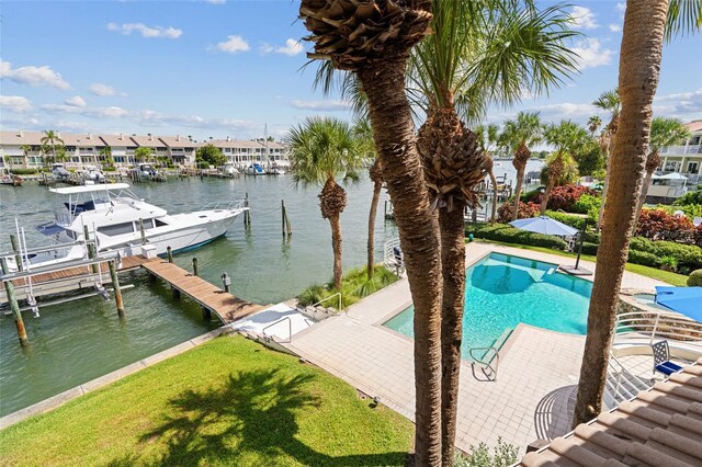 exterior space featuring a community pool, a water view, and a yard