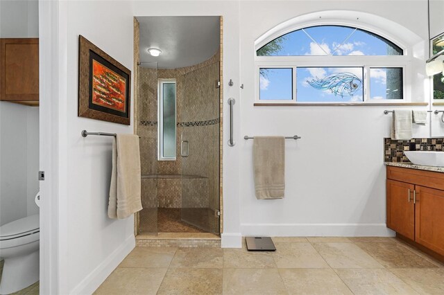 bathroom featuring vanity, toilet, walk in shower, and tile patterned flooring