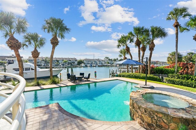 view of swimming pool with a water view, a patio area, and an in ground hot tub