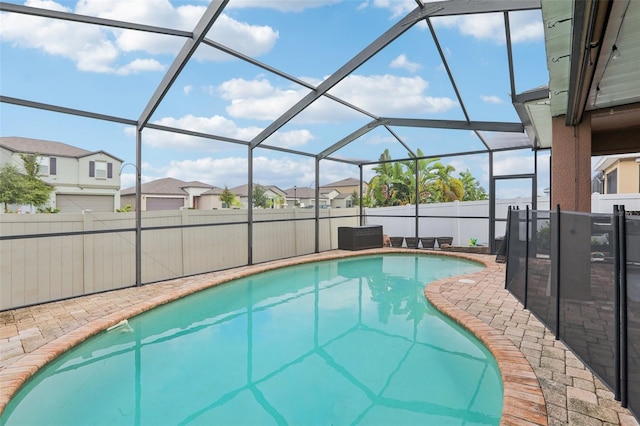 view of swimming pool featuring glass enclosure and a patio area