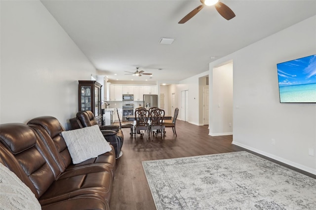 living room with ceiling fan and dark wood-type flooring