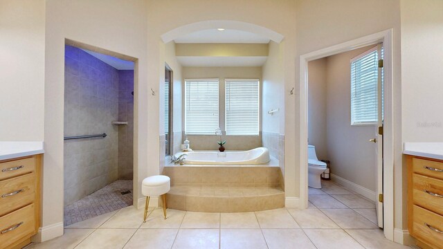 full bathroom with vanity, toilet, separate shower and tub, and plenty of natural light