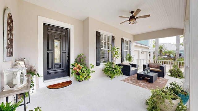 view of exterior entry with ceiling fan and covered porch