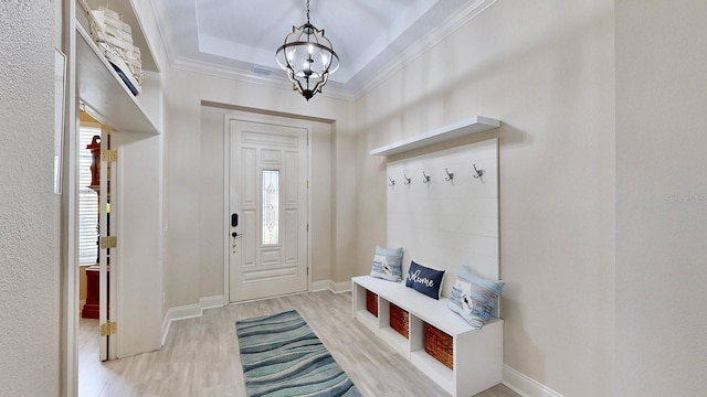 mudroom featuring a raised ceiling, crown molding, a chandelier, and light wood-type flooring