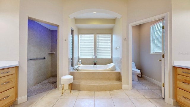 bathroom featuring vanity, a bath, plenty of natural light, and toilet