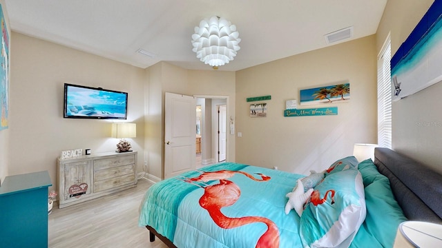 bedroom with light wood finished floors and baseboards