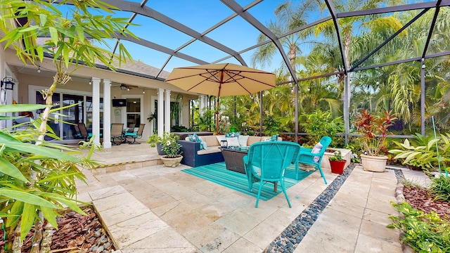 view of patio with an outdoor living space, ceiling fan, and glass enclosure