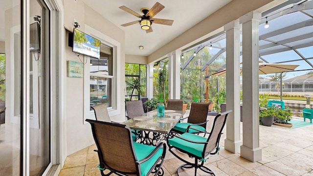 sunroom / solarium featuring a ceiling fan and outdoor dining space